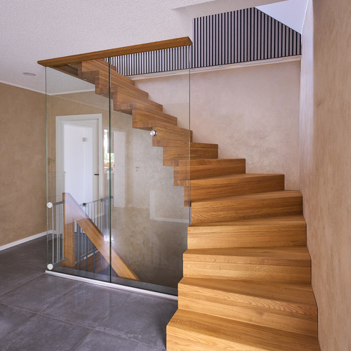Faltwerktreppe mit Glaswand als Geländer in einem Treppenhaus Faltwerktreppe mit Glaswand als Geländer in einem Treppenhaus